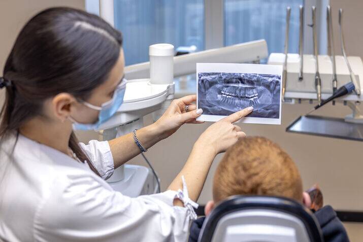 Dentist holding and explaining a dental X-ray