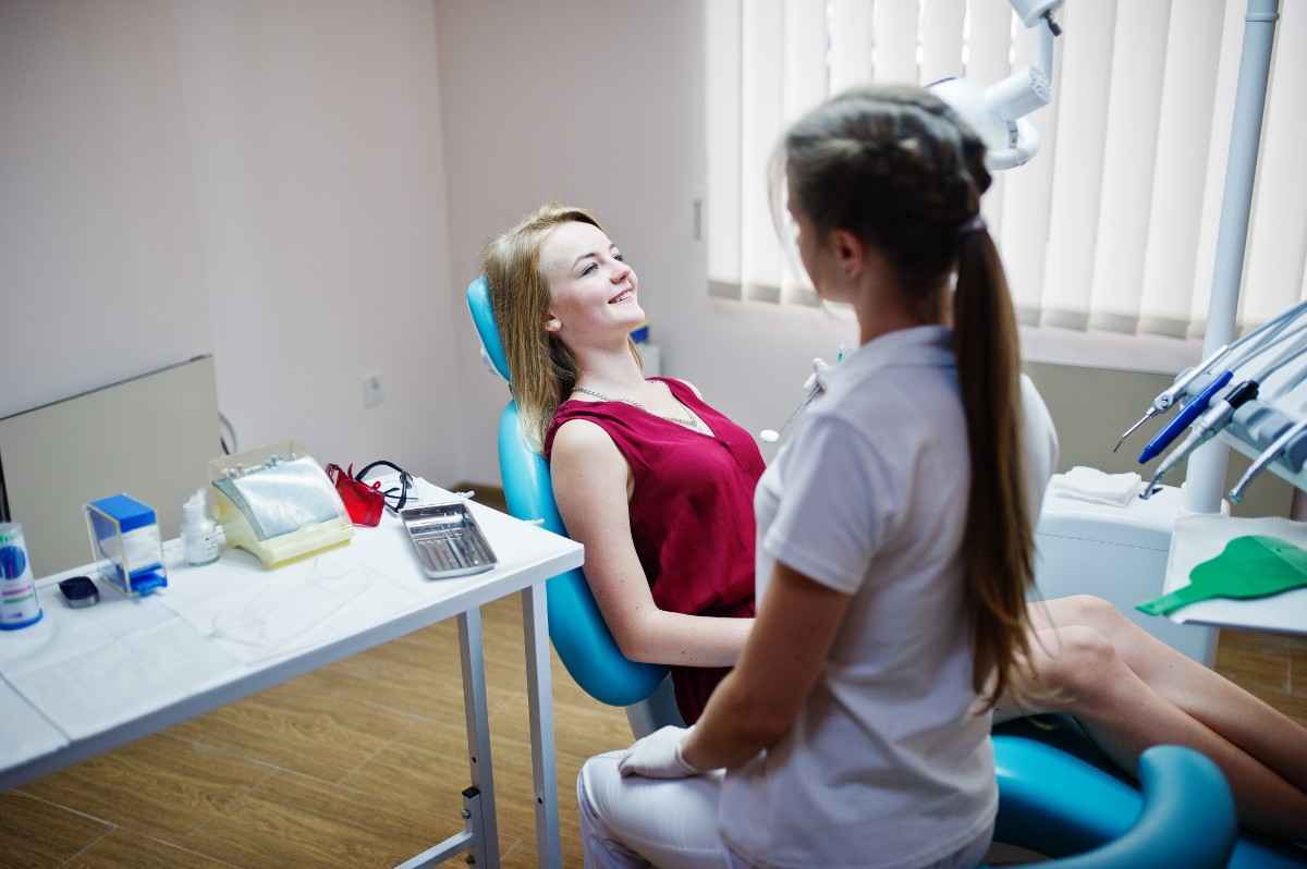 Patient speaking with a dentist during a dental visit in a modern dental office exam room